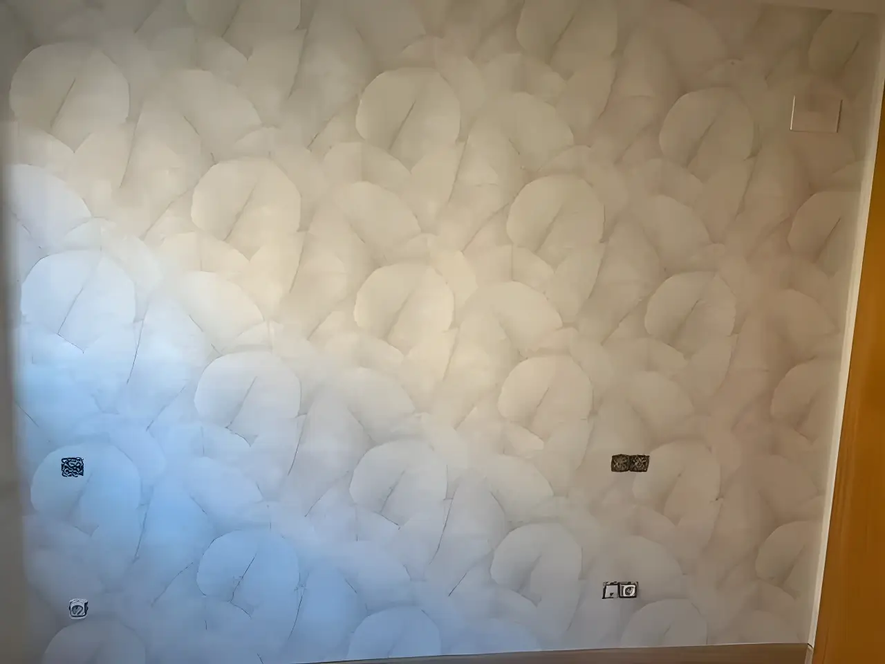 Pintores en Badajoz aplicando papel pintado de textura clara en salón reformado